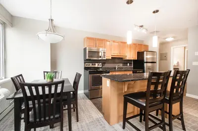 a kitchen with a table and chairs and a counter top at Canterra Suites Hotel in Edmonton