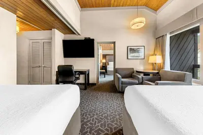 a hotel room with two beds and a flat screen tv at Best Western Plus Banff International Lodge in Banff