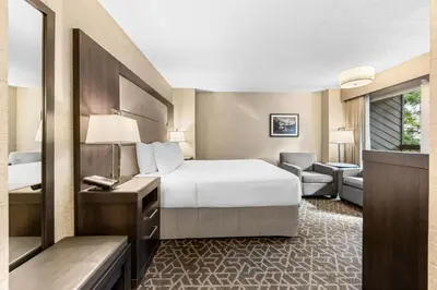 a hotel room with a bed and a chair at Best Western Plus Banff International Lodge in Banff