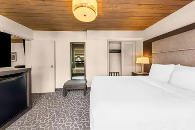 a hotel room with a bed and a flat screen tv at Best Western Plus Banff International Lodge in Banff
