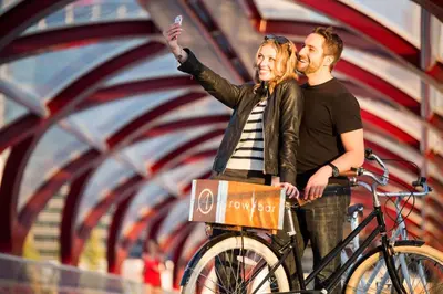 a man and a woman standing next to a bike at Hotel Arts in Calgary