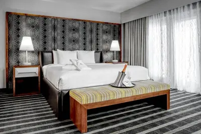 a hotel room with a large bed and a bench at Hotel Arts in Calgary