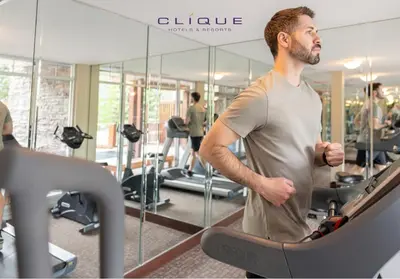 a man running on a treadmill in a gym at Falcon Crest Lodge by CLIQUE in Canmore