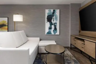 a living room with a white couch and a tv at Doubletree By Hilton West Kelowna in West Kelowna
