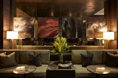 a lobby with a couch and paintings on the wall at Loden Vancouver in Vancouver