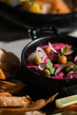 a bowl of soup with olives and onions on a table at Paradox Vancouver in Vancouver