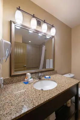 a bathroom with a sink and a large mirror at Bayview Hotel in Courtenay