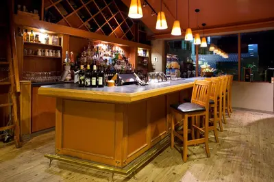a bar in a restaurant with a counter and chairs at Holiday Inn Hotel & Suites Osoyoos by IHG in Osoyoos