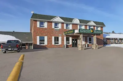 a truck parked in front of a brick building at Guest House Inn & Suites in Edson