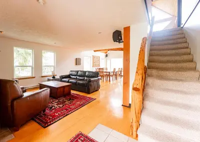 a living room with a staircase and a couch at Wild Coast Wilderness Resort in Port Renfrew