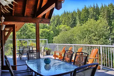 a patio with a table and chairs on a deck at Wild Coast Wilderness Resort in Port Renfrew