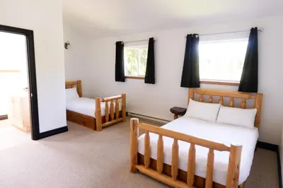 a bedroom with two beds and a mirror at Wild Coast Wilderness Resort in Port Renfrew