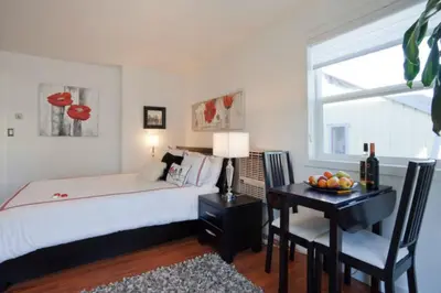 a bedroom with a bed and a desk and a window at A Float Home B&B in Fisherman’s Wharf in Victoria