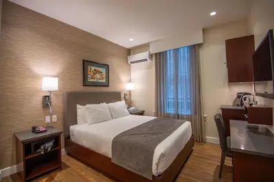 a hotel room with a bed and a desk and a window at Strathcona Hotel in Victoria
