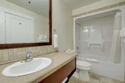 a bathroom with a sink and a toilet and a mirror at Strathcona Hotel in Victoria