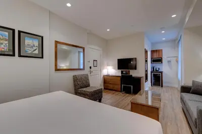 a hotel room with a bed and a living room at Strathcona Hotel in Victoria