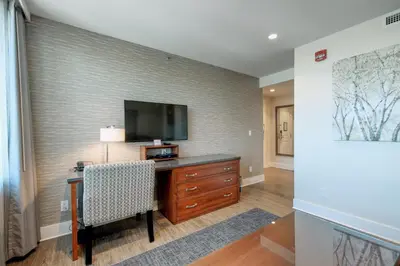 a room with a desk with a television on a wall at Strathcona Hotel in Victoria