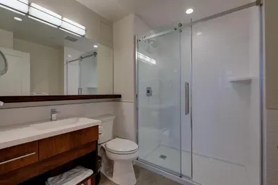 a bathroom with a shower and a toilet and a sink at Strathcona Hotel in Victoria