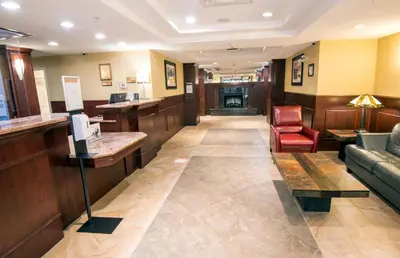 a waiting room with a couch and a bar at Holiday Inn Express Hotel & Suites Edson by IHG in Edson
