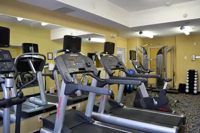 a gym with several treadmills and elliptical machines at Holiday Inn Express Hotel & Suites Edson by IHG in Edson