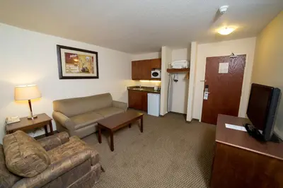a living room with a couch and a kitchen at Holiday Inn Express & Suites Drayton Valley by IHG in Drayton Valley