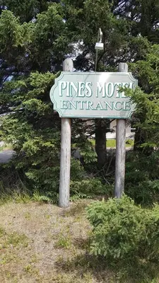 a sign for pines nolect entrance in a field at Pines Motel in Hinton