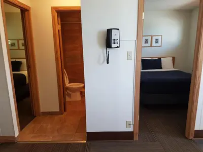 a room with a bed and a phone on the wall at Pines Motel in Hinton