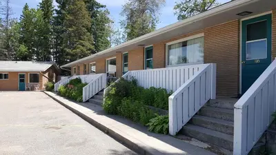 a house with a white fence in front of it at Pines Motel in Hinton
