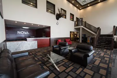 a lobby with leather furniture and a nova sign on the wall at Nova Inn Manning in Manning