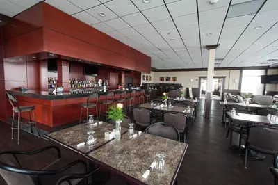 a restaurant with tables and chairs and a bar at Nova Inn Manning in Manning