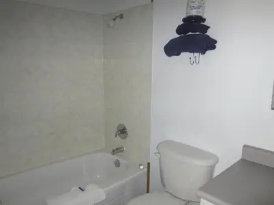 a bathroom with a toilet and a bath tub and a toilet at Bonanza Gold Motel & RV Park in Dawson City