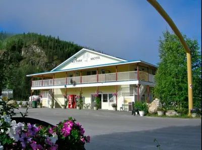 a large building with a large parking lot with flowers at Bonanza Gold Motel & RV Park in Dawson City