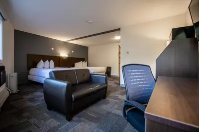 a hotel room with a bed and a chair at Bedrock Motel in Mayo Landing