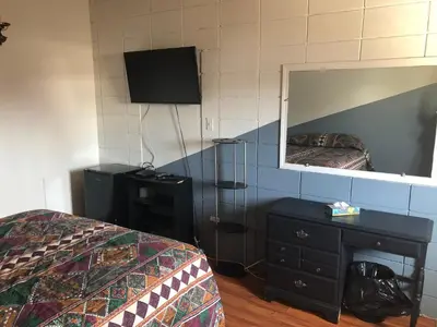 a bedroom with a mirror and a bed and a dresser at Superlodge Lloydminster in Lloydminster