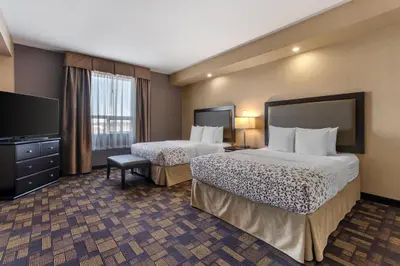 a hotel room with two beds and a flat screen tv at Best Western PLUS Fox Creek in Fox Creek