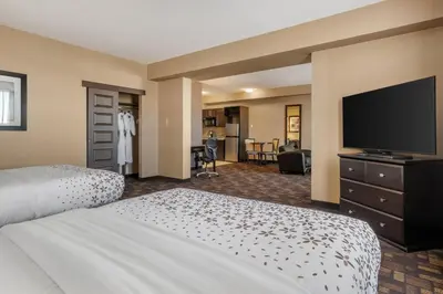 a hotel room with two beds and a flat screen tv at Best Western PLUS Fox Creek in Fox Creek