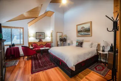 a bedroom with a bed and a living room at Beaujolais Boutique B&B at Thea's House- Adults Only in Banff