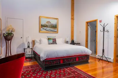 a bedroom with a bed and a red rug at Beaujolais Boutique B&B at Thea's House- Adults Only in Banff