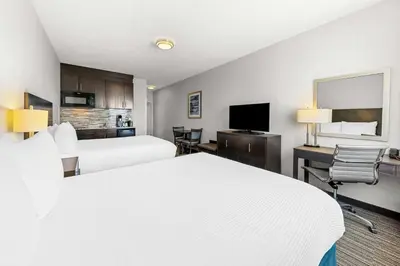 a hotel room with two beds and a flat screen tv at Best Western Plus Airdrie Gateway in Airdrie