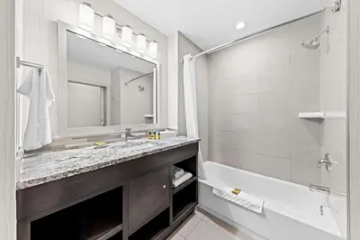 a bathroom with a sink and a tub and a mirror at Best Western Plus Airdrie Gateway in Airdrie