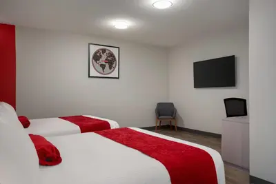 a hotel room with two beds and a flat screen tv at Ramada by Wyndham West Edmonton Hotel & Suites in Edmonton