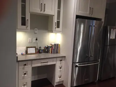 a kitchen with white cabinets and a stainless steel refrigerator at Vancouver Austin Guesthouse in Coquitlam