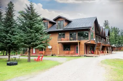 a large house with red chairs in front of it at Jasper Gates Resort in Jasper