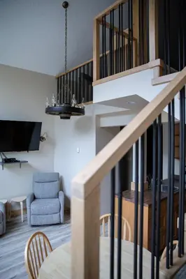 a living room with a staircase and a chair at Jasper Gates Resort in Jasper