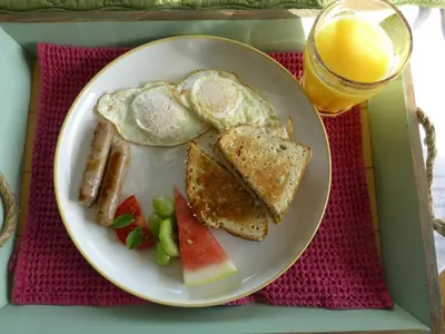 a plate of breakfast food with toast and fruit and a glass of orange juice at Overlander B&B in Kamloops