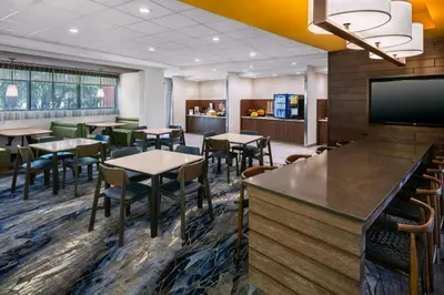 a restaurant with tables and chairs and a flat screen tv at Fairfield Inn & Suites by Marriott Edmonton North in Edmonton