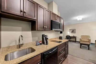 a kitchen with a sink and a microwave at Best Western Plus Lacombe Inn and Suites in Lacombe