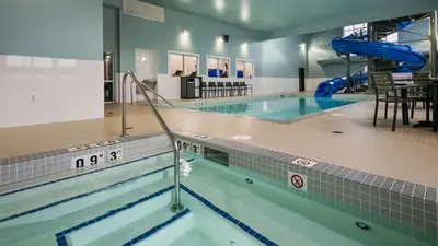 a swimming pool with a slide in the middle at Best Western Plus Lacombe Inn and Suites in Lacombe