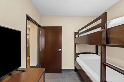 a bedroom with two bunk beds and a television at Best Western Plus Lacombe Inn and Suites in Lacombe