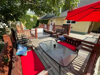 a table and benches on a deck with a red umbrella at Blaeberry Valley Vacation Rentals in Golden